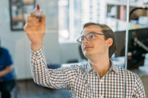 Benesch employee writing on glass during a meeting