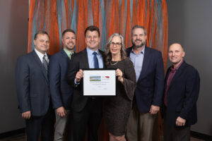 A photo of the Benesch Niobrara West Bridges project team with award and Jeanne McClure