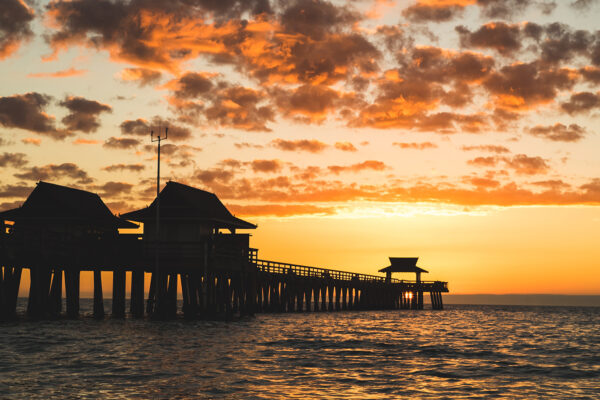 pier on the ocean with sunset in background