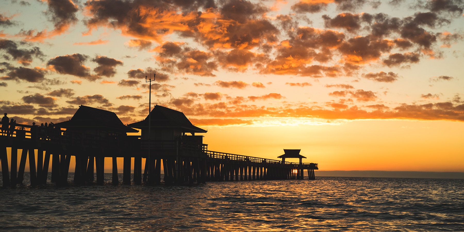 pier on the ocean with sunset in background