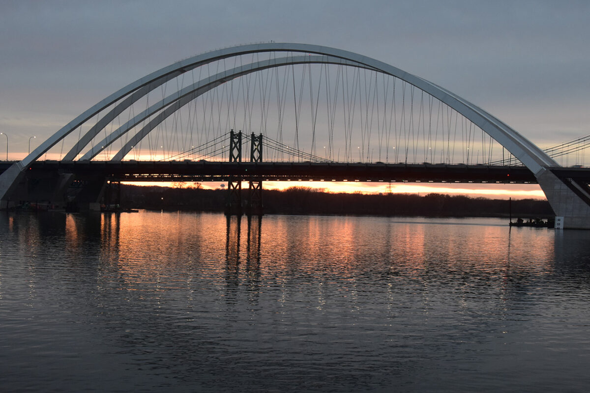 A photo of the I-74 bridge over the Mississippi river at sunset