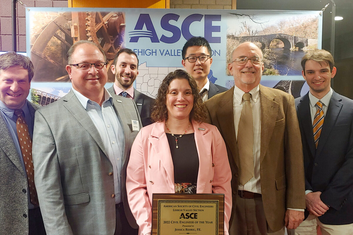 A photo of Jessica Rehrig holding ASCE award with Benesch team