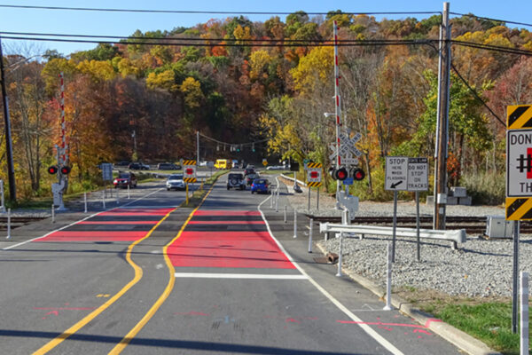 Photo of an active warning stop system on Roaring Brook Road at an at-grade railroad crossing