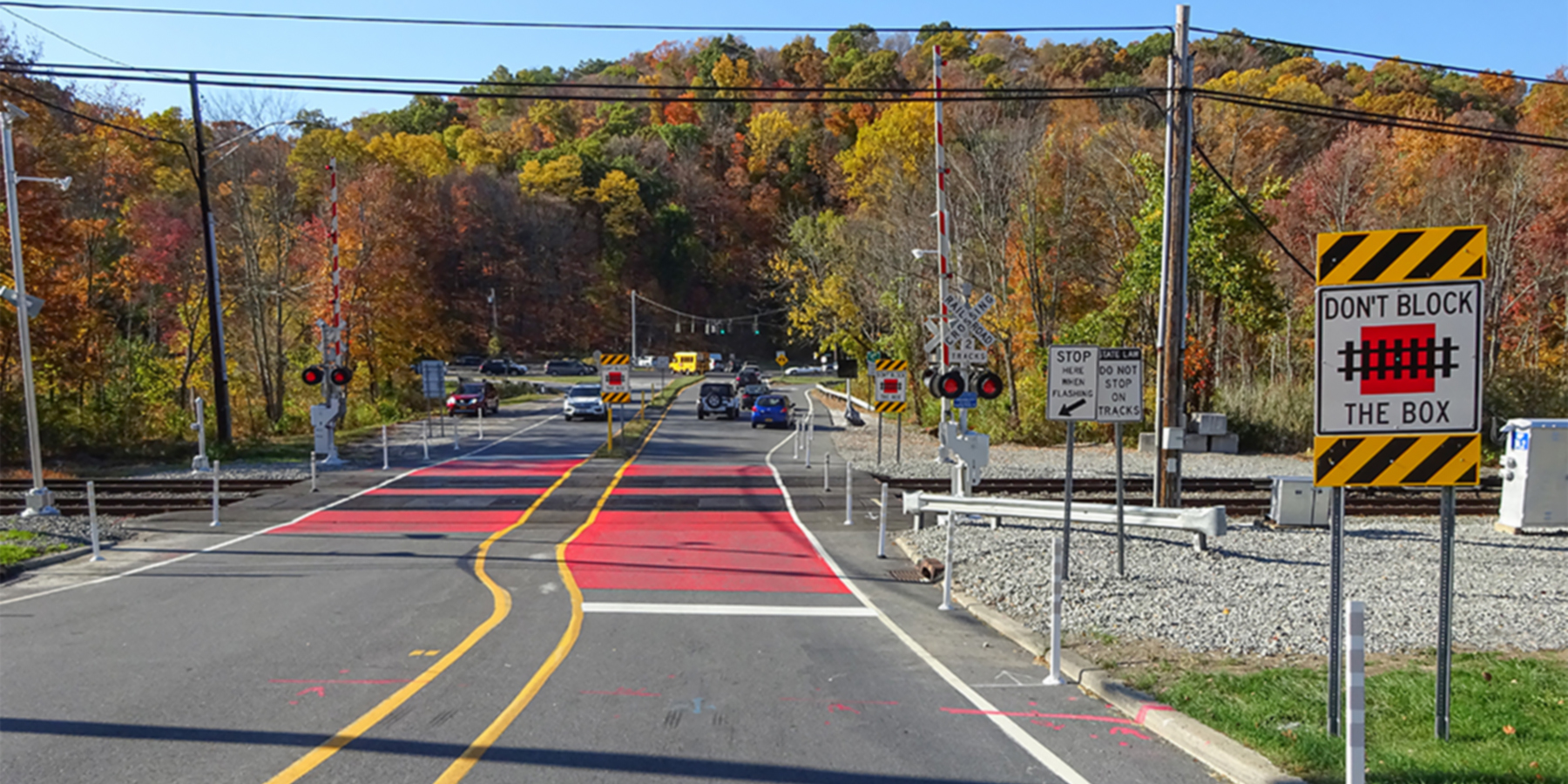 Photo of an active warning stop system on Roaring Brook Road at an at-grade railroad crossing