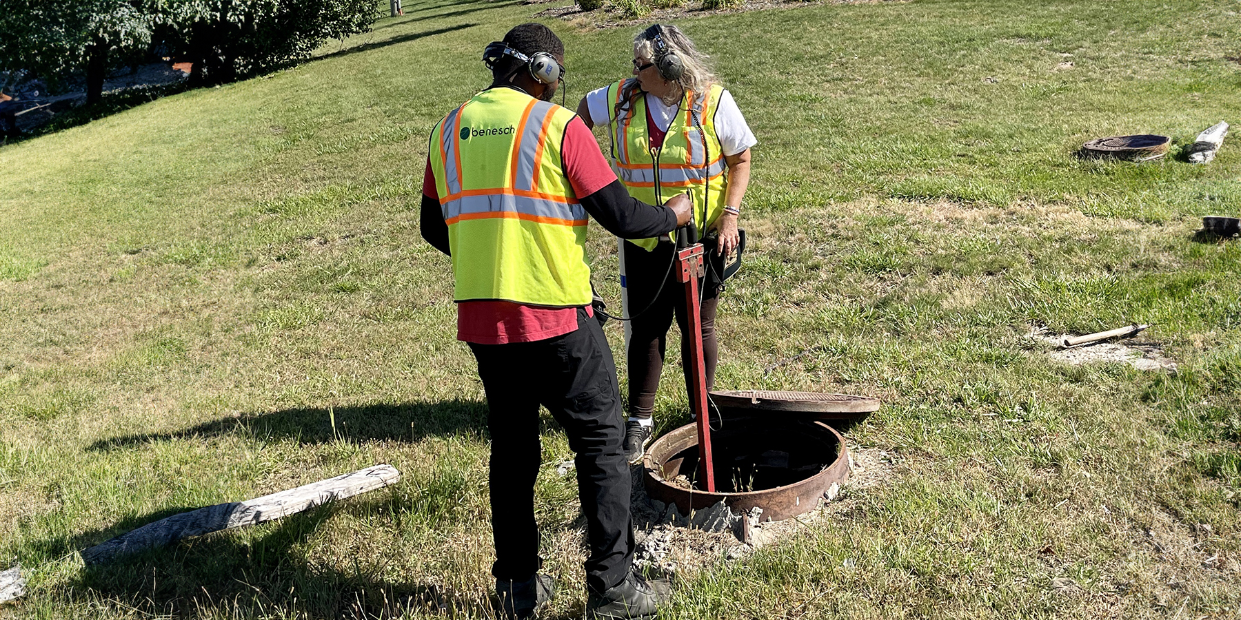 image of two Benesch water inspectors performing a leak detection at an open manhole in Romulus, MI.