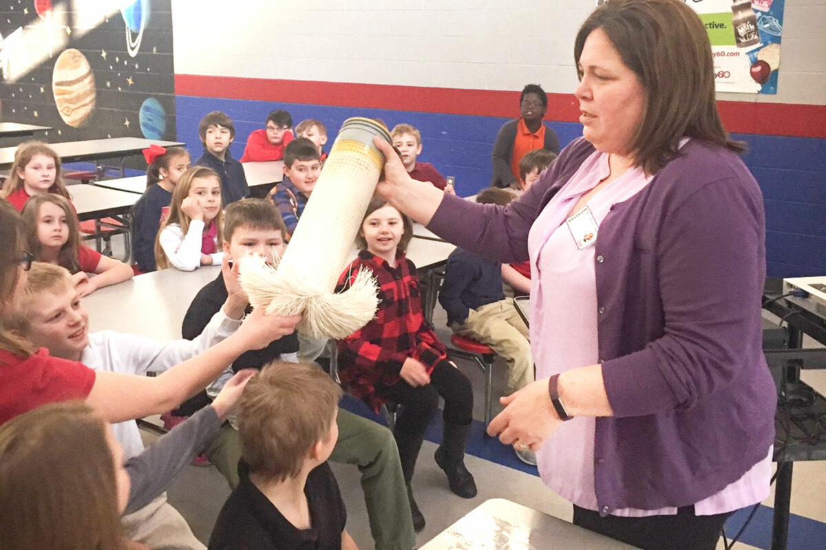 a photo of a Benesch engineer teaching an elementary school about water engineering