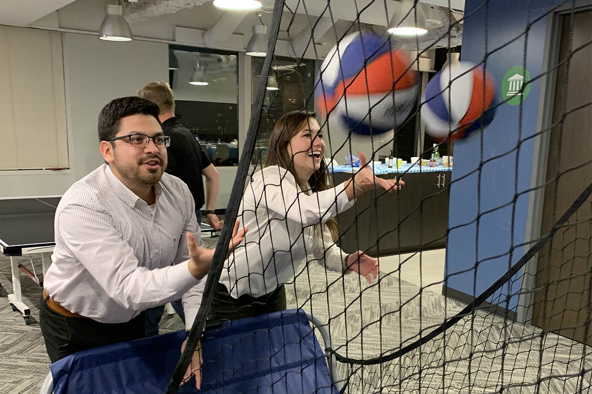 photo of Benesch colleagues playing pop-a-shot during happy hour