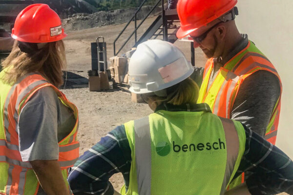 Photo of Benesch employees reviewing a construction schedule on the field