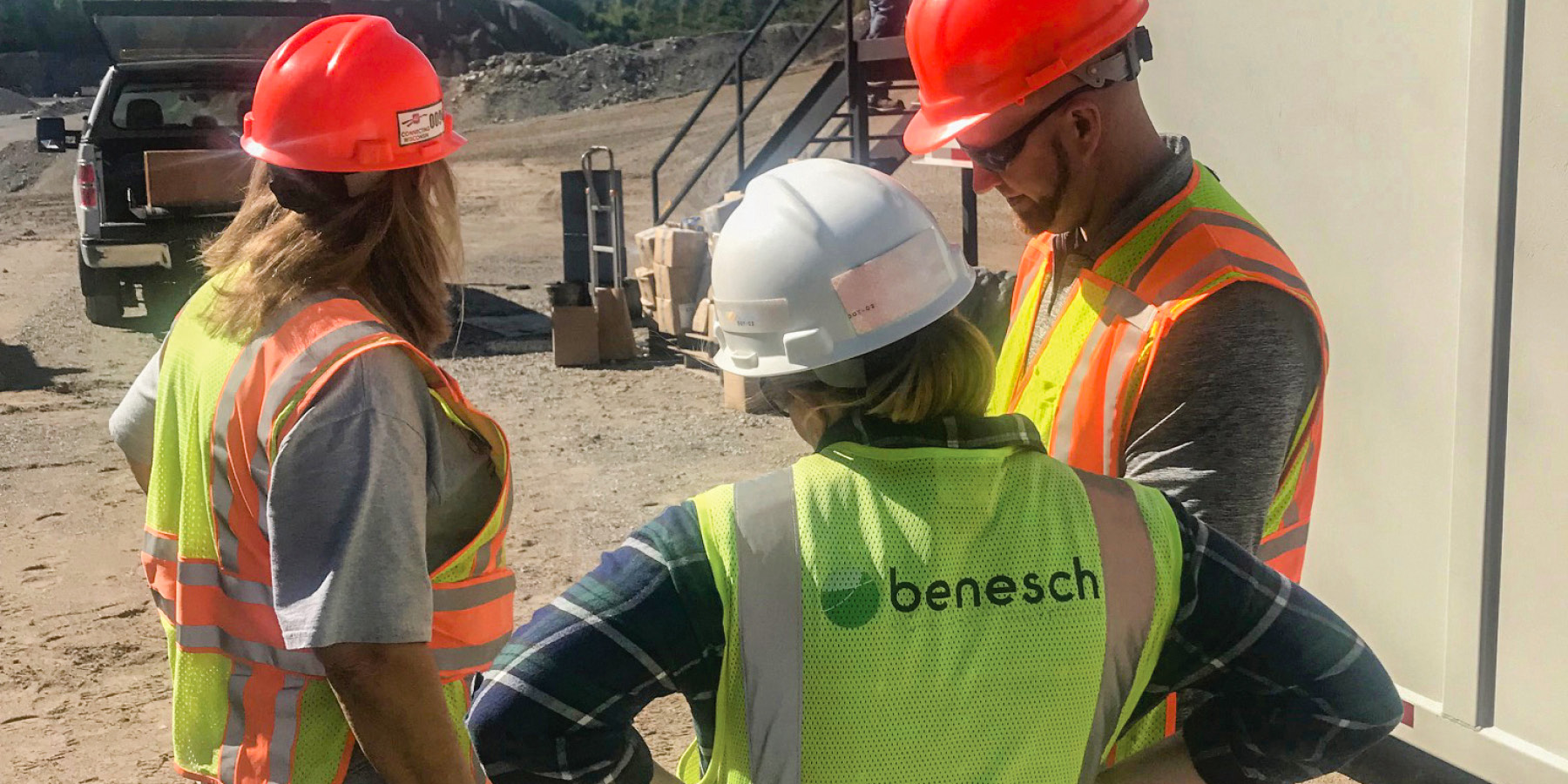 Photo of Benesch employees reviewing a construction schedule on the field