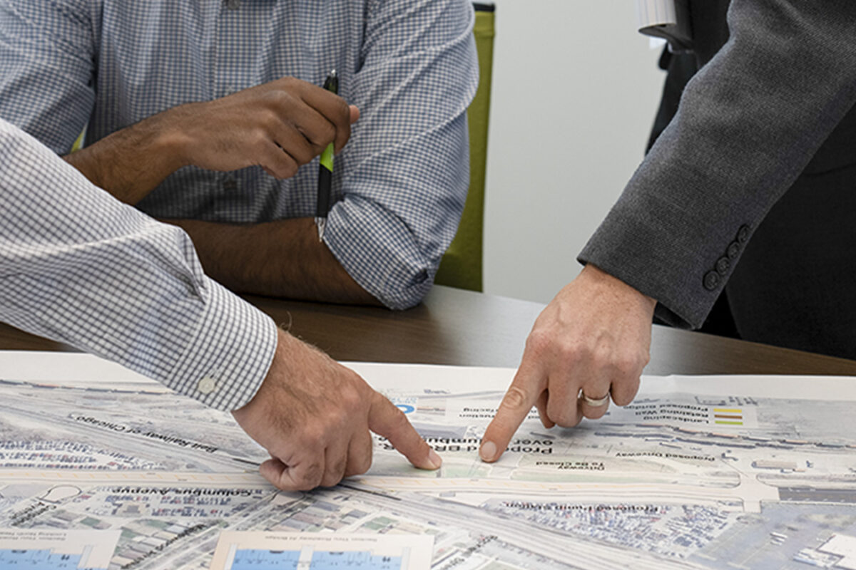 Photo of Benesch employees reviewing a set of plans in conference room