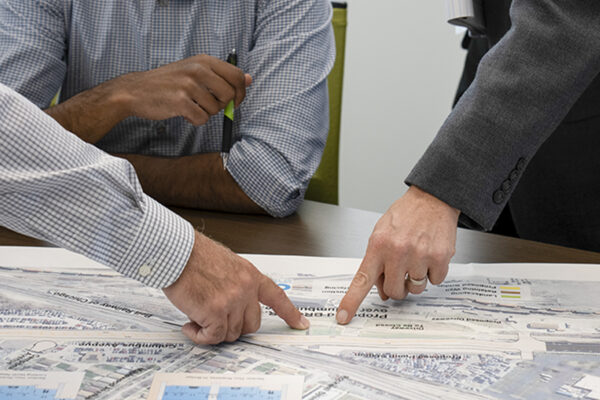 Photo of Benesch employees reviewing a set of plans in conference room