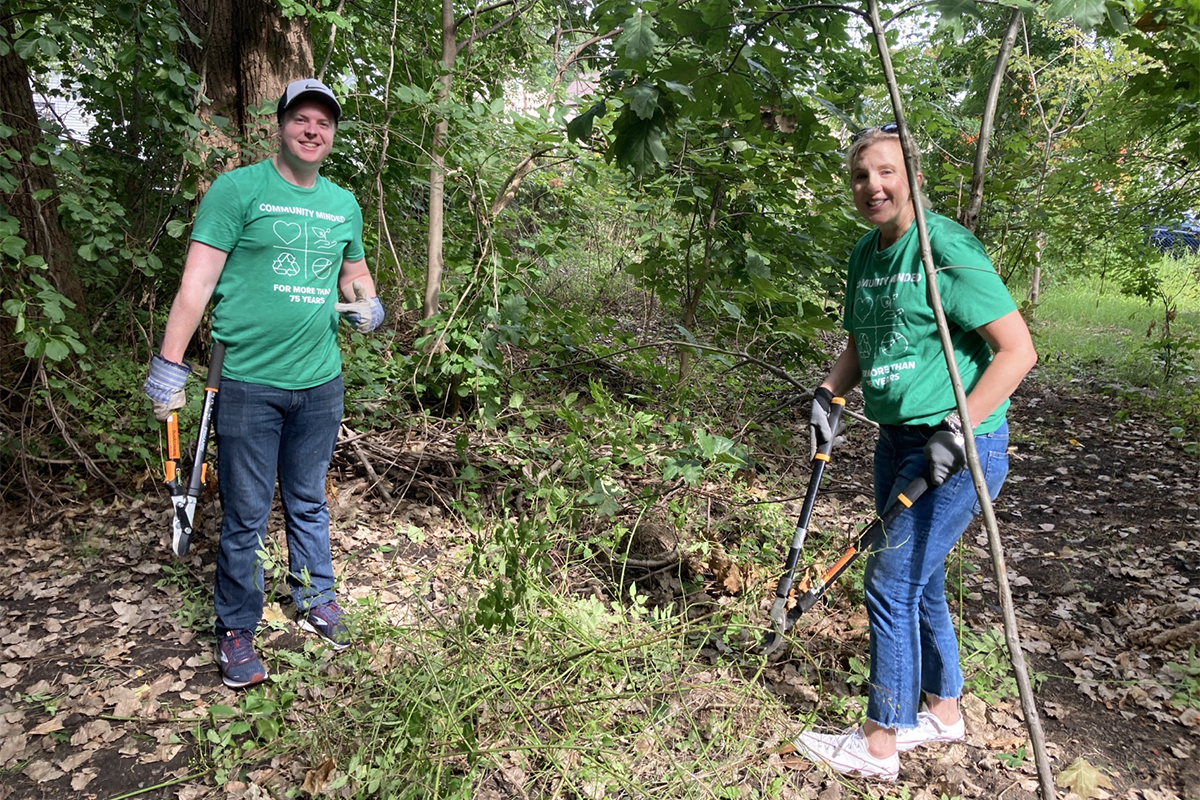 Benesch employees clearing debris in a park during a summer service outing