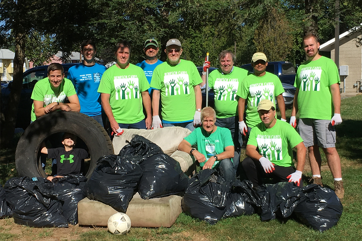 Benesch employees clearing debris in a park during a summer service outing