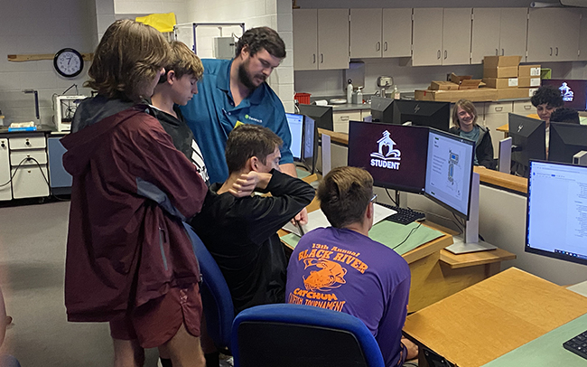 A photo of a group of high school students working at computers