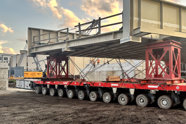 Photo of the new Jackson Street Bridge loaded onto a self-propelled modular transporter before it was placed on its new alignment.