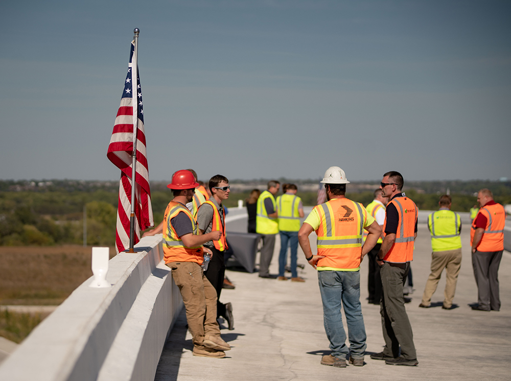 A photo of Benesch employees wearing orange vests on a highway bridge