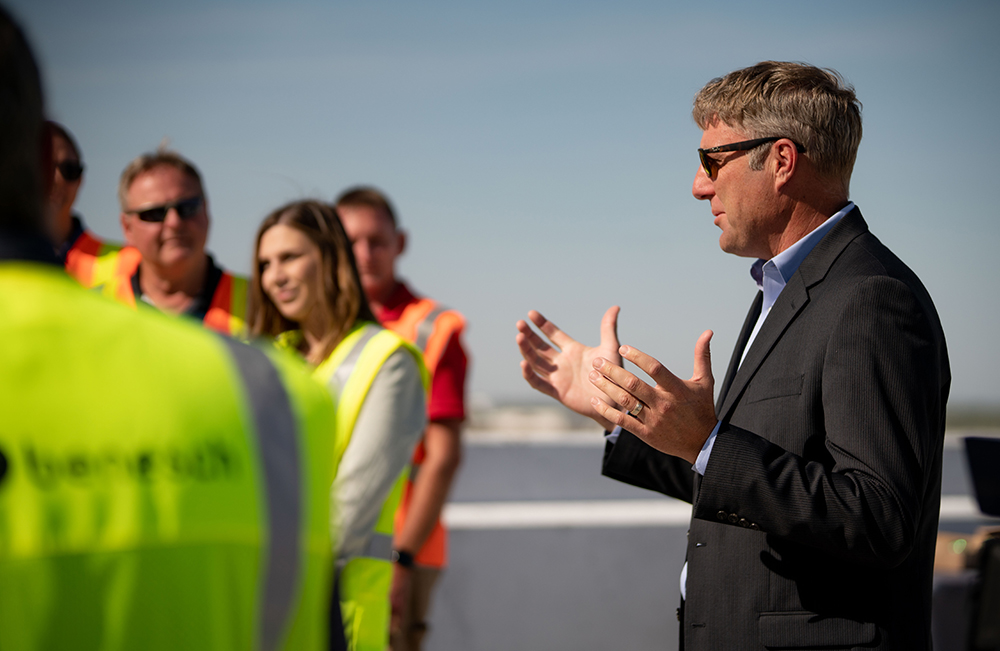 A photo of Tony Dirks talking to group of Benesch employees wearing construction outfits