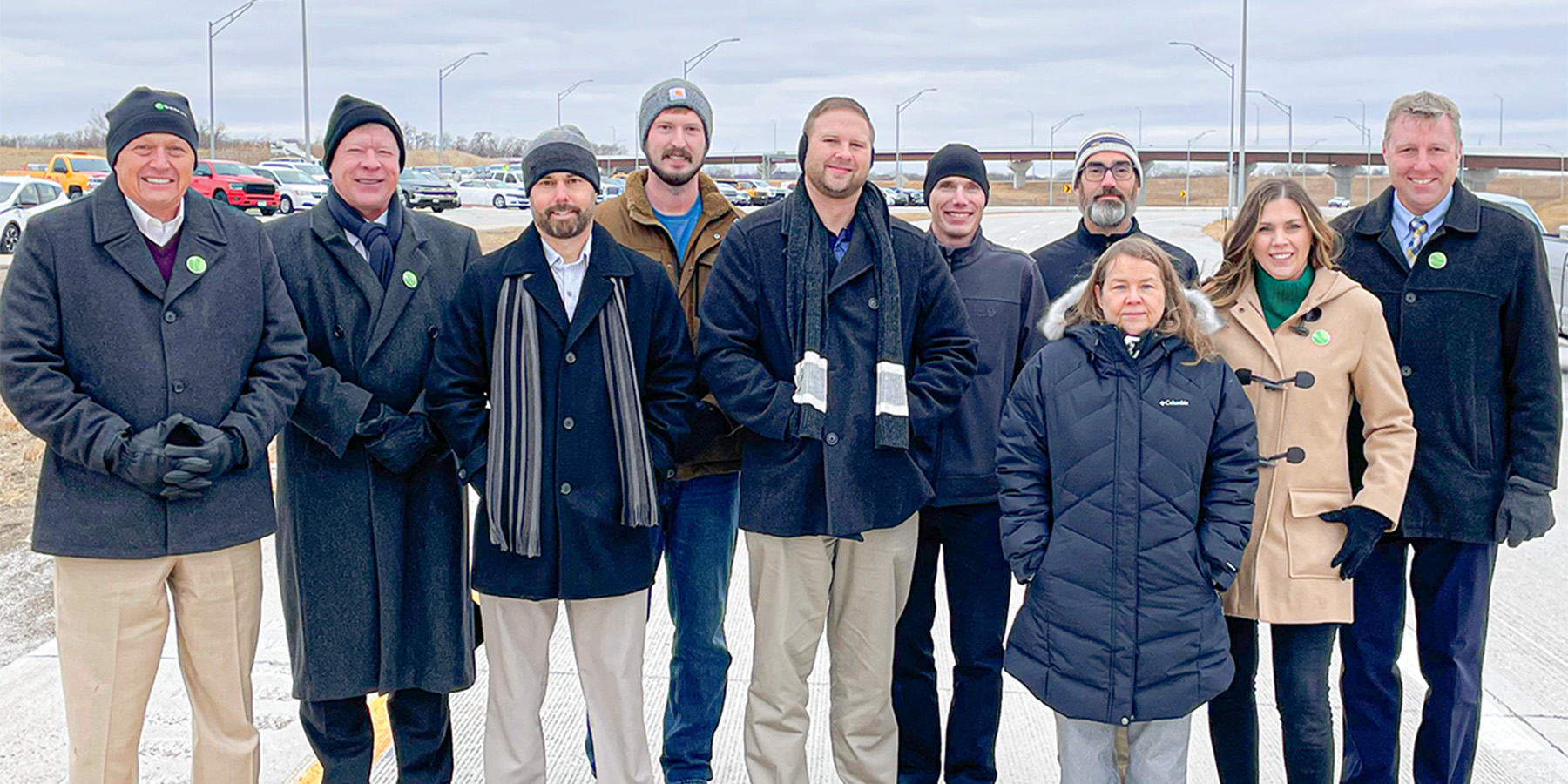 A photo of the Benesch team at the ribbon cutting smiling dressed in winter coats