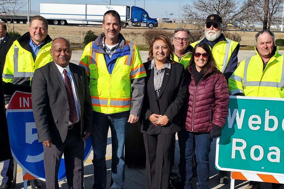 A photo of the ribbon cutting ceremony near a Weber Road sign