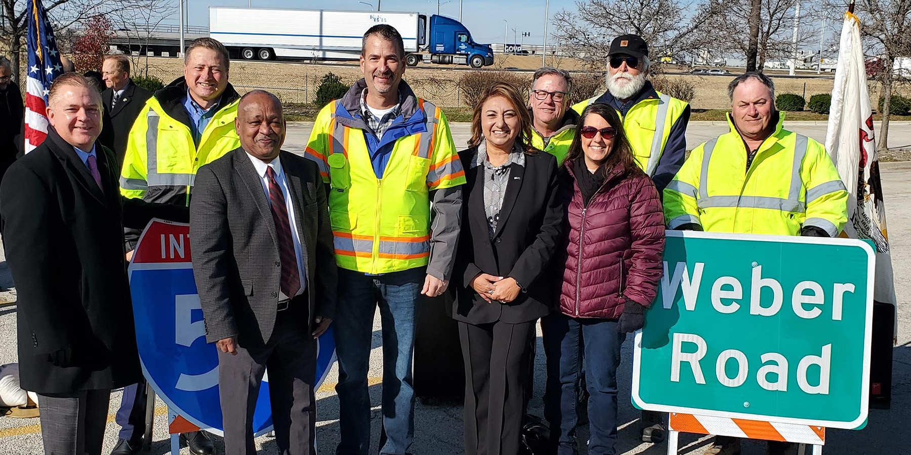 A photo of the ribbon cutting ceremony near a Weber Road sign