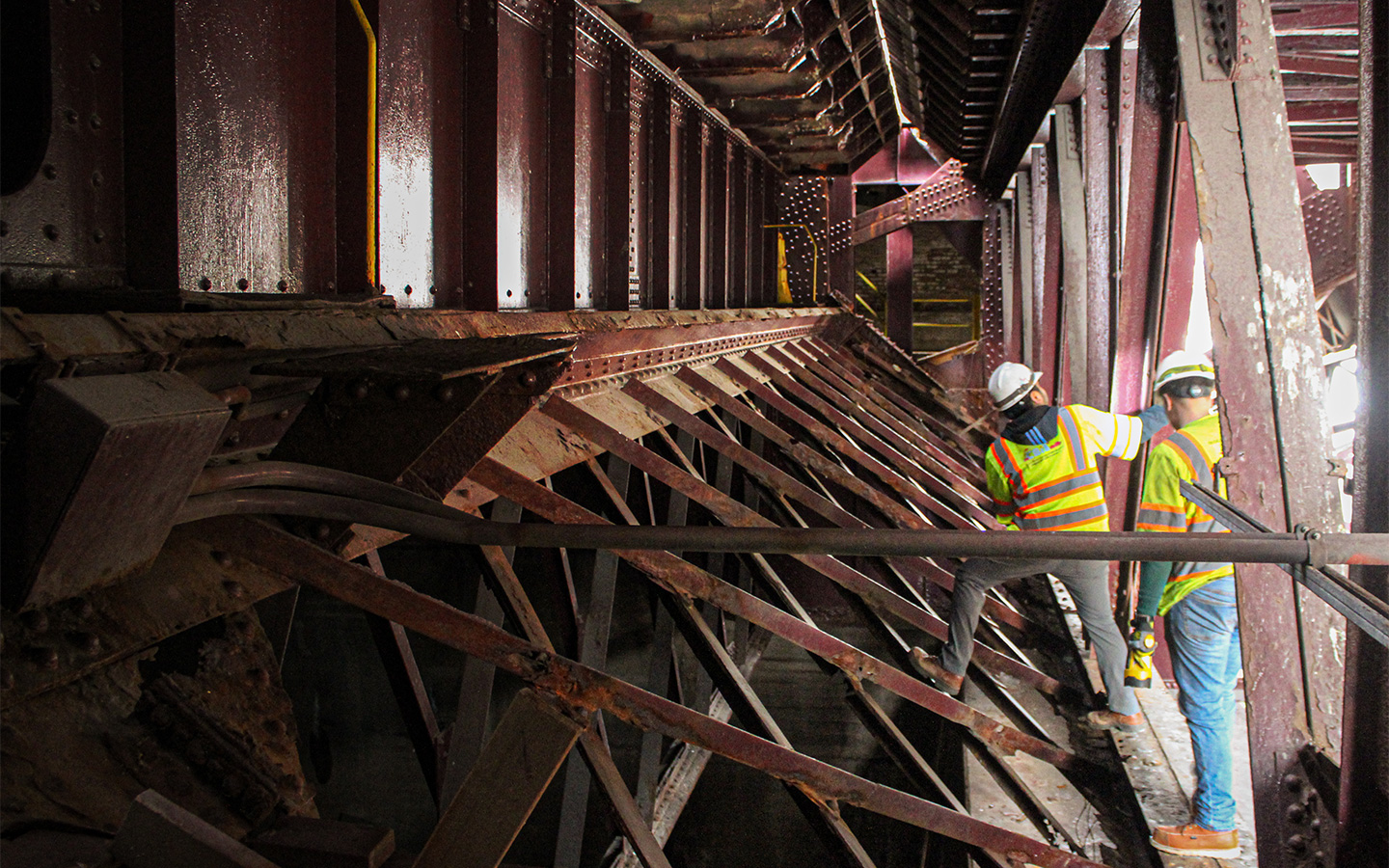 Photo of inspectors looking for potential corrosion, section loss, or cracks.