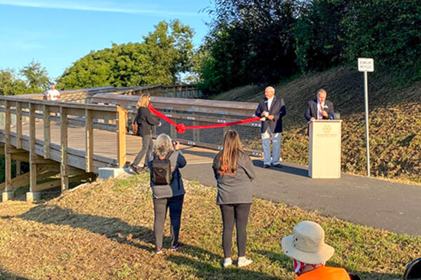 Photo of the ribbon cutting ceremony of the Phase IIID of the River Levee Trail during the Hawk’s Gully Hurdle 10K.