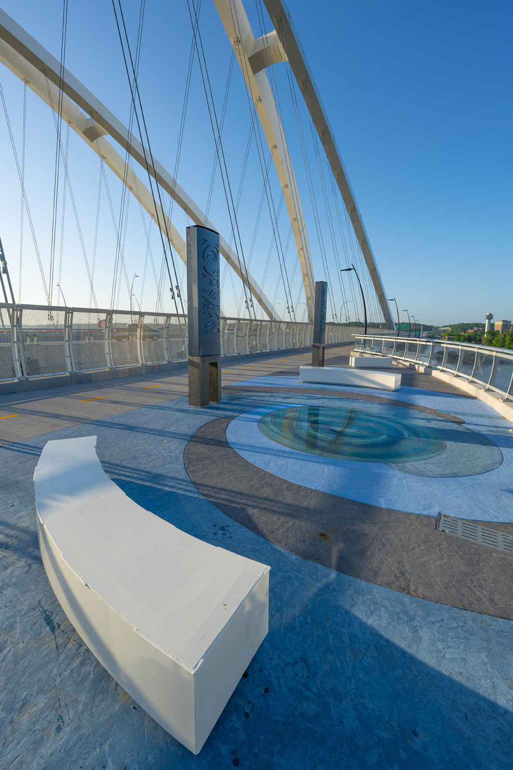 A photo of benches and a pavement with a swirl design on the I-74 Mississippi River Bridge