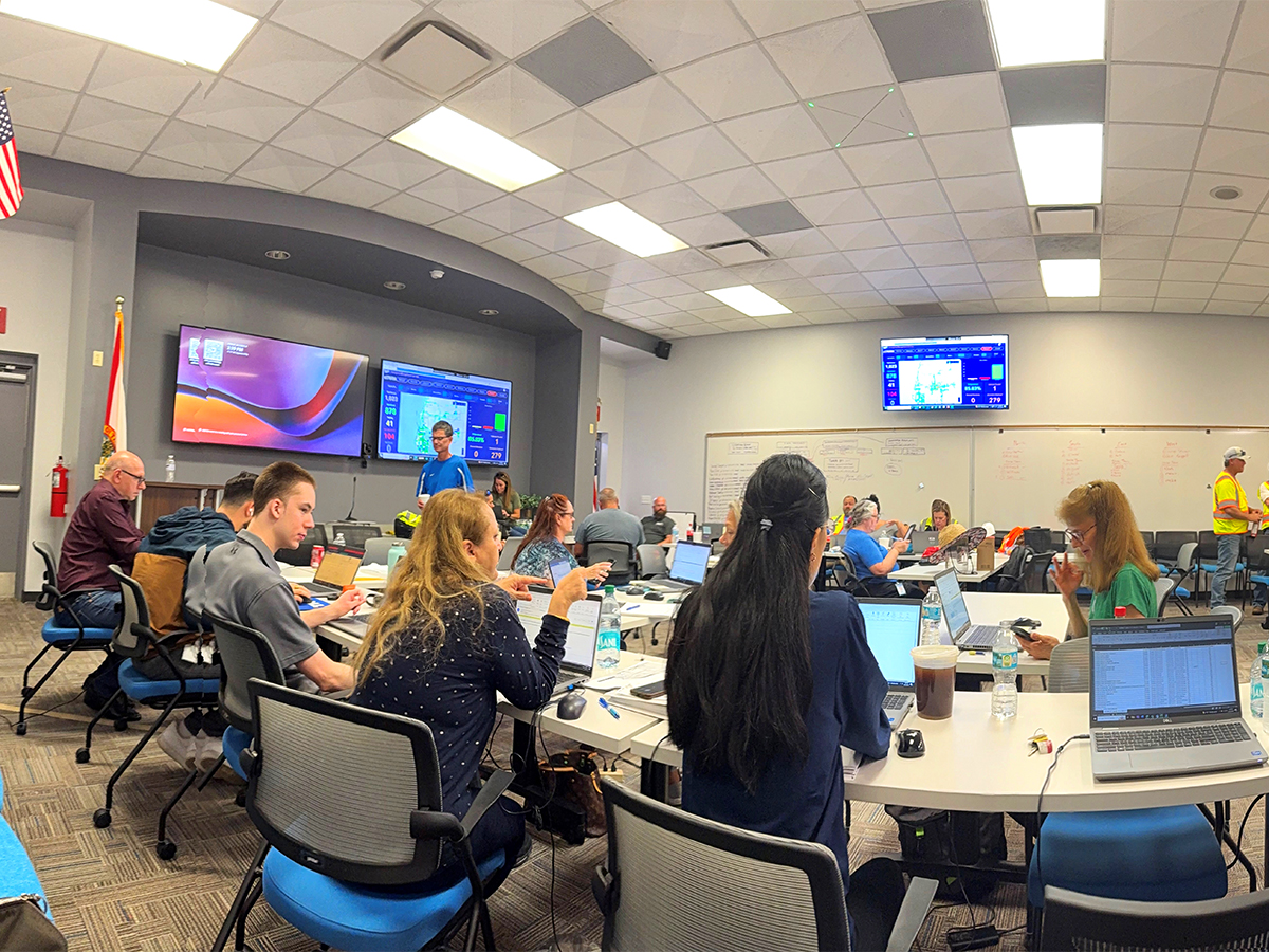 Large room with volunteers sitting at desks helping with hurricane relief efforts.
