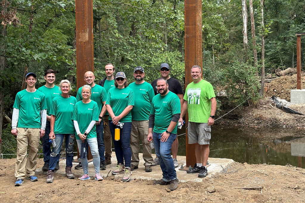 Employees stand in front of new trail alignment