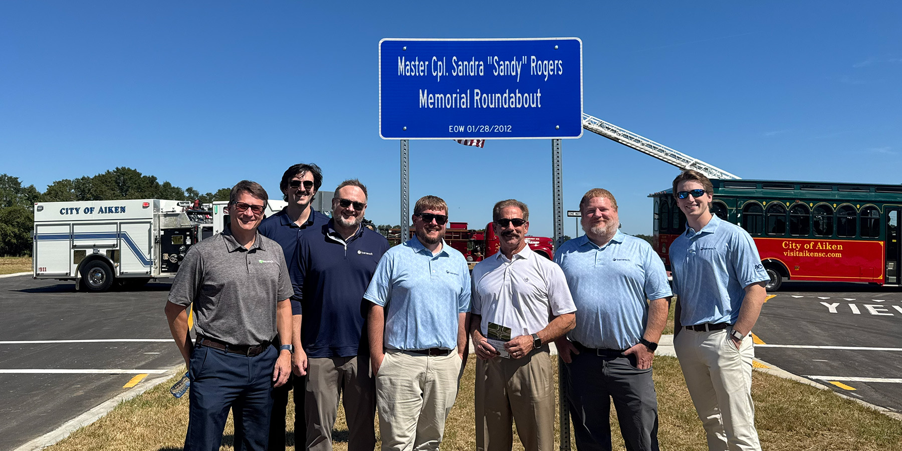 Benesch stand on Tribute Parkway in front of dedication sign